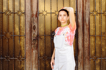 slender model with trendy hairstyle of teenage generation Z posing near vintage door