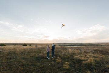 A happy couple flies a kite and spends time together outdoors in a nature reserve. Happy relationships and family vacations. Freedom and space.