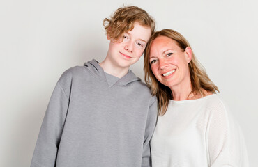 Photo of mother and adorable teen boy looking at camera.