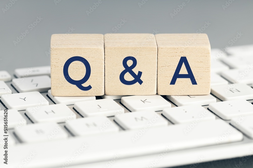 Poster q&a word on wooden block on computer keyboard.