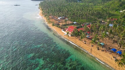 Aerial drone view of a beautiful tropical island with a sandy beach and palm trees in Philippines