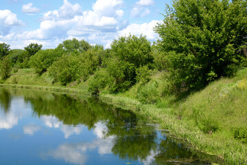 Fototapeta na wymiar European landscape. High bank of a small calm river.