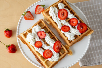 Homemade waffles with fresh strawberries and cream