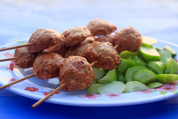 Cambodian street food skewers served with fresh cucumber pieces
