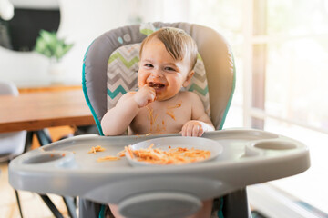 Little baby eating her dinner and making a mess