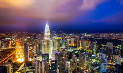 Fototapeta premium Aerial shot of the cityscape of Kuala Lumpur glowing in the night lights.