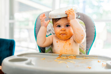 Little baby eating her dinner and making a mess