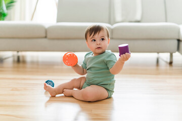 Cute 8 month baby laying on floor, playing with toys - obrazy, fototapety, plakaty