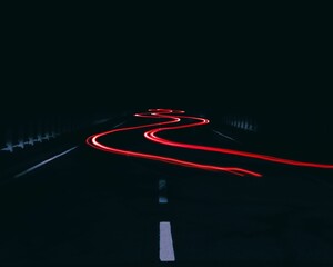 Winding car light trail in the darkness