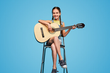 Girl sitting on chair and playing guitar