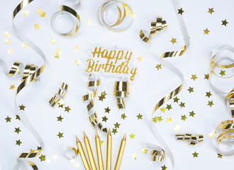  composition with golden stars, serpentine and candles on white background ,concept for celebrating a birthday, anniversary or party in Gold tones