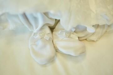 Fototapeta na wymiar Small feet of a newborn baby in socks. The concept of motherhood and childhood.