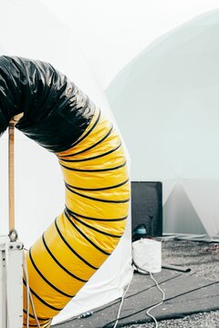Vertical shot of a yellow flexible air ducting against a white blurry background