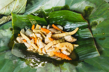 Stir-Fried bamboo shoots with pork served on a banana leaf, a traditional khmer dish 
