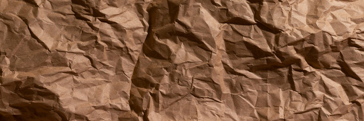 Brown crumpled, wrinkled recycle craft paper texture background banner. Wide panoramic header