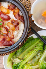 top view clay pot rice of Chinese style sausage and air-dried bacon with soup and cabbage vertical composition
