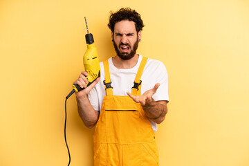young man looking angry, annoyed and frustrated. handyman with a drill