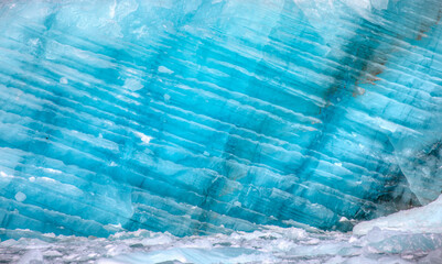 A close-up of the layered surface of a blue glacier - Knud Rasmussen Glacier near Kulusuk -...