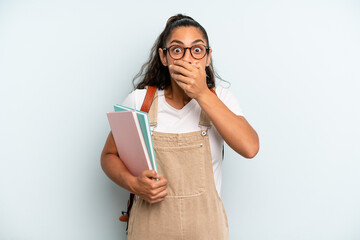 hispanic woman covering mouth with hands with a shocked. university student concept