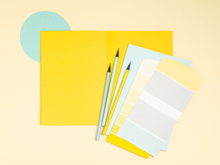 Simple, bright and colourful artists, designers workplace background with place for text. Colour samples palette, notebook, pens, pencils frame for people of creative professions and students.