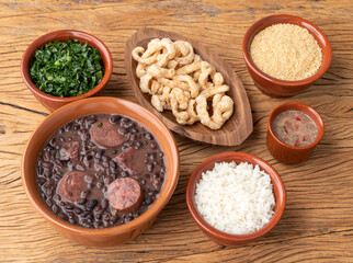 Typical brazilian feijoada with kale, rice, farofa, cracklings and pepper