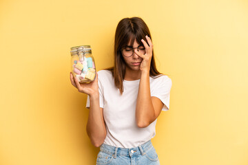 hispanic woman feeling bored, frustrated and sleepy after a tiresome. candies bottle concept