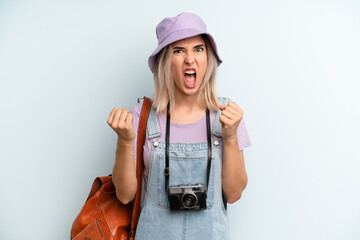 blonde woman shouting aggressively with an angry expression. summer tourist concept