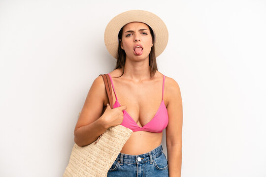 pretty girl feeling disgusted and irritated and tongue out. summer and hat concept