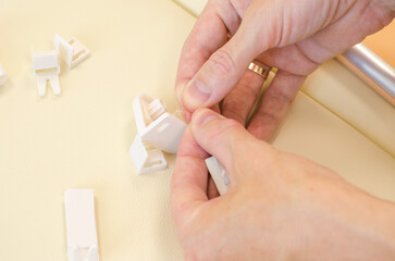 Assembly of roller blinds. Male hands are assembling roller blinds, close-up.