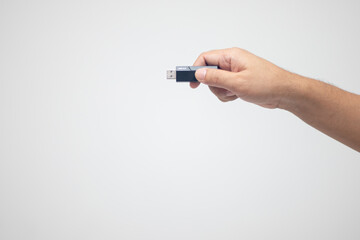 hand holding a flash drive on a white background