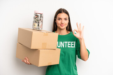 pretty woman feeling happy, showing approval with okay gesture. volunteer and donation concept