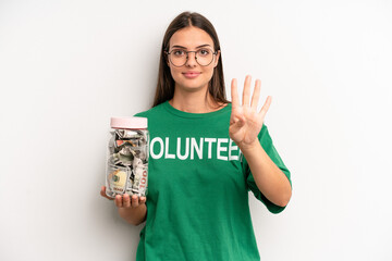 pretty woman smiling and looking friendly, showing number four. volunteer and donation concept