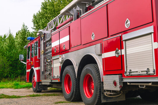 A fire truck with a retractable ladder for the delivery of firefighters to the place of fire and the supply of extinguishing agents to the burning hearth. Fire truck in the open air. Fire safety.