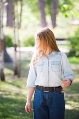 Young girl on a summer sunny day. Hair shines in the sun.  Jeans styles.