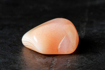 Mineral pink agate on a black concrete background. The concept of using minerals and crystals in...
