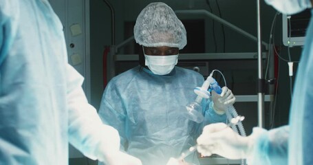 A team of surgeons perform an operation in a bright operating room