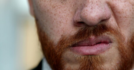 Fototapeta premium Upset man snarling close-up eyes and mouth. Redhead red beard grimacing angry person