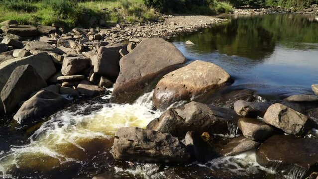 Beautiful view of a river flowing past and over rocks in Dunbeath Strath, Scottish Highlands