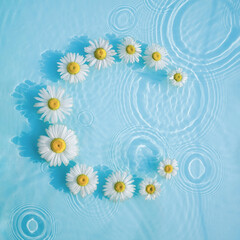Water background with flowers and drops on the surface