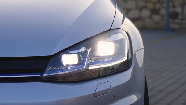 Car Headlights Flashing Led Lamp. Car with Headlight Flashing Smoothly Close up. Car Front Full Led Light with a Blurry Background and a Nice Colour