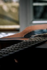 Closeup shot of a brown guitar under the shadow lights