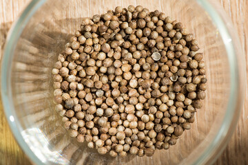 Dried seeds coriander (Coriandrum sativum) on the kitchen table. Ingredient for spices. Culinary background texture. Top view.