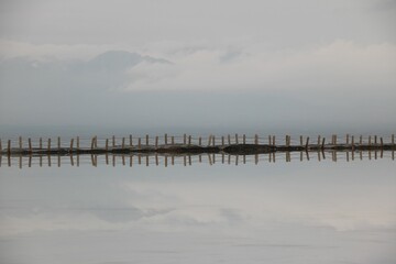 Breathtaking view of a dock on cloudy sky background ideally reflected in water