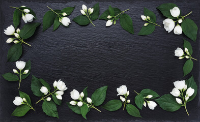 White jasmine flowers on a black surface. Rectangular frame of jasmine flower on a black...