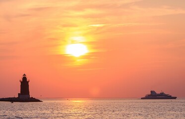 Delaware Breakwater East End Lighthouse and Cape May-Lewes Ferry against sunset © Jon267/Wirestock Creators