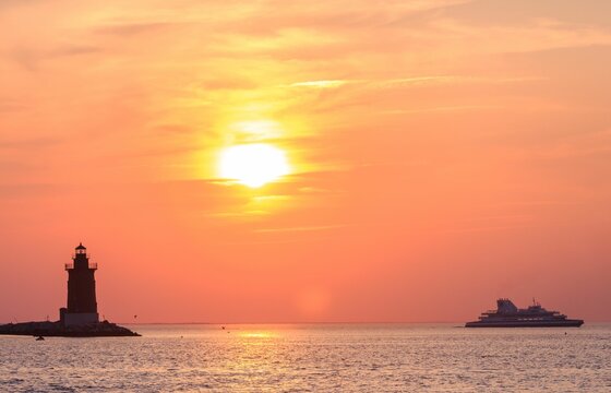 Delaware Breakwater East End Lighthouse and Cape May-Lewes Ferry against sunset