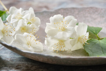 Obraz na płótnie Canvas Close up of white jasmine flowers on a plate. Shallow depth of field