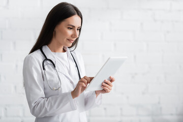 Brunette doctor using digital tablet in clinic