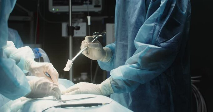 A team of surgeons perform an operation in a bright operating room
