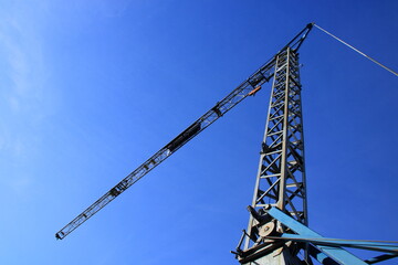 Ausleger eines Baukranes vom Boden fotografiert vor einem blauen Himmel